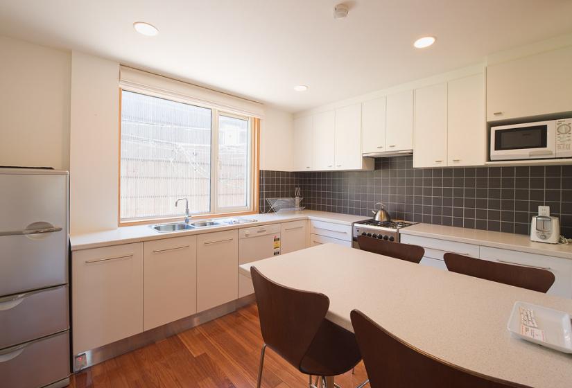 Kitchen with white cupboards and white table