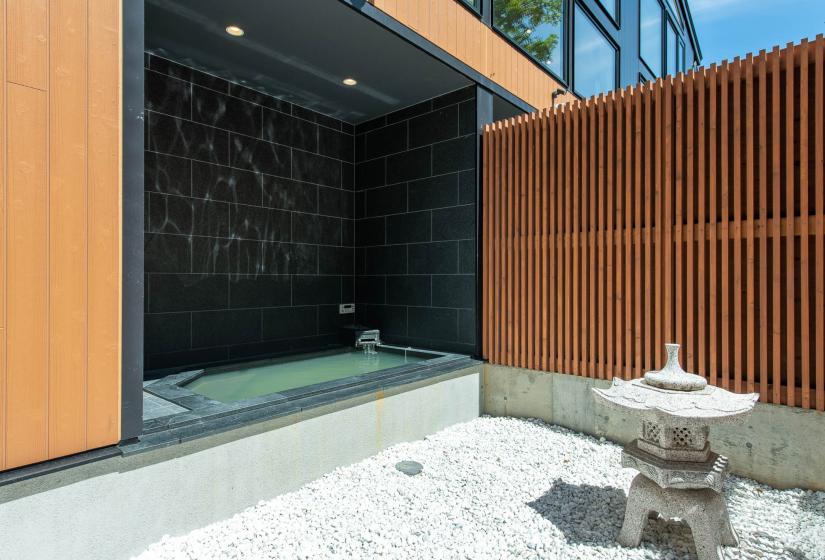 An Onsen bath with garden ornament to the righ