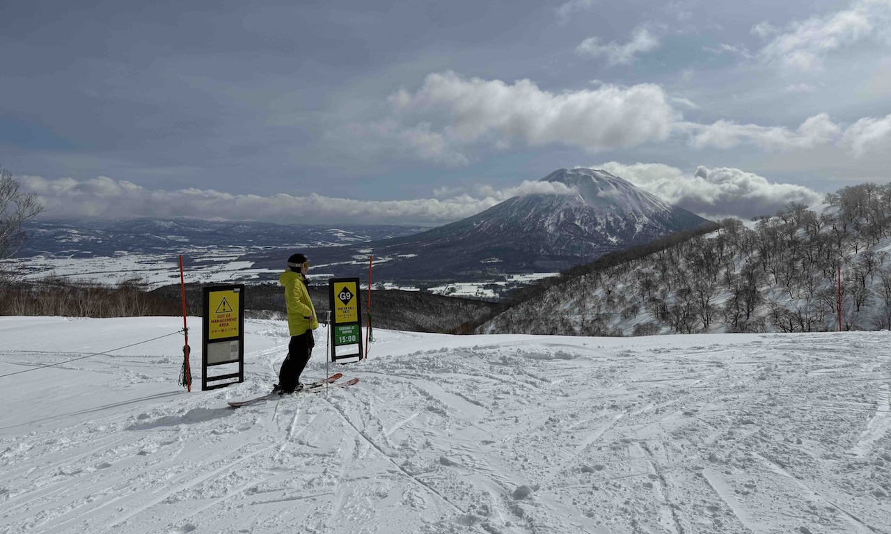 A skier stands beside a backcountry gate