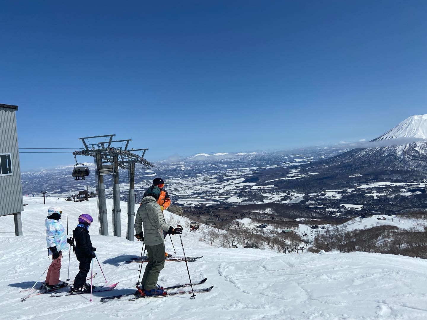 A family of skiers stand with their instrctor