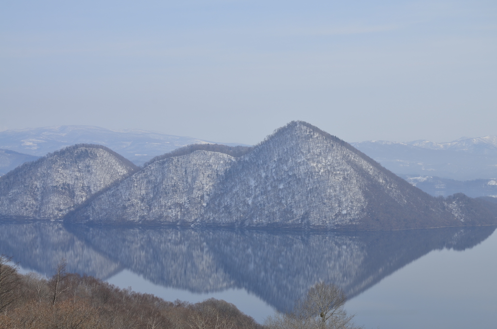 3 island in a lake covered in forest and snow