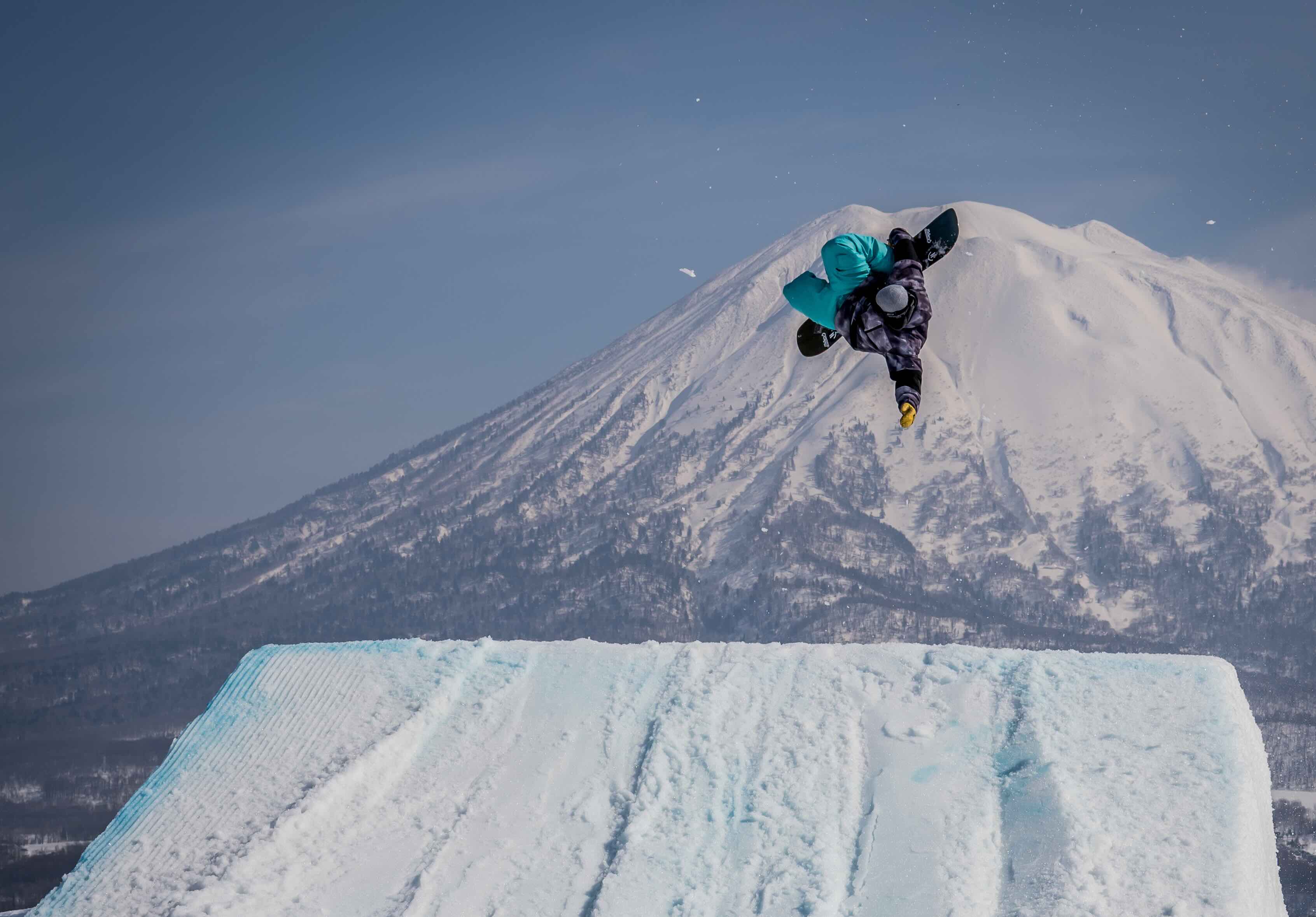 A snowboarder performs an arial manouvre