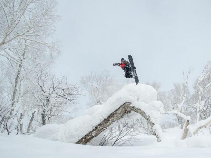 A snowboarder performs a method air