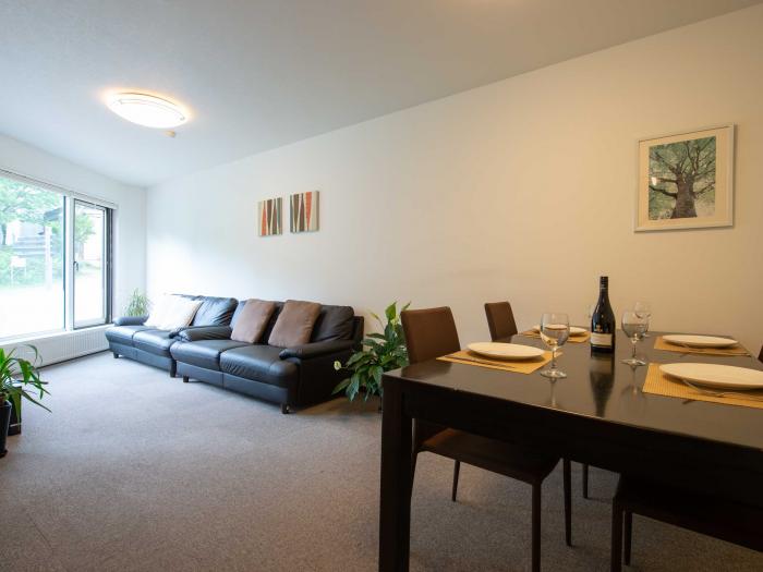 Yukon Apartments - Living room view with table set and 2 black sofas Living room view with table set and 2 black sofas