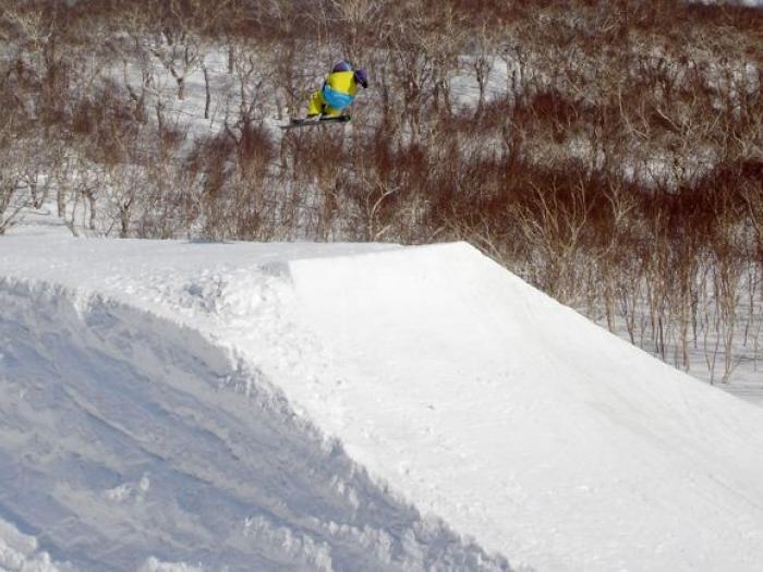 A skier hitting a hip jump.