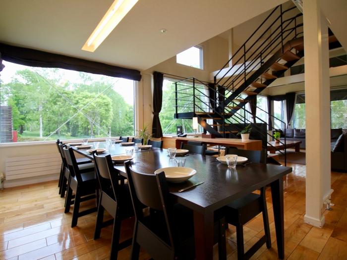 A black dining table set with white plates