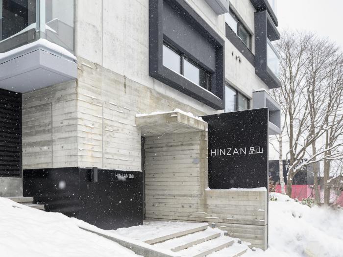 Hinzan exterior A concrete building with black window frames.