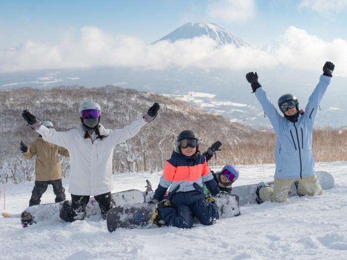 4 snowboarders kneeling in the snow