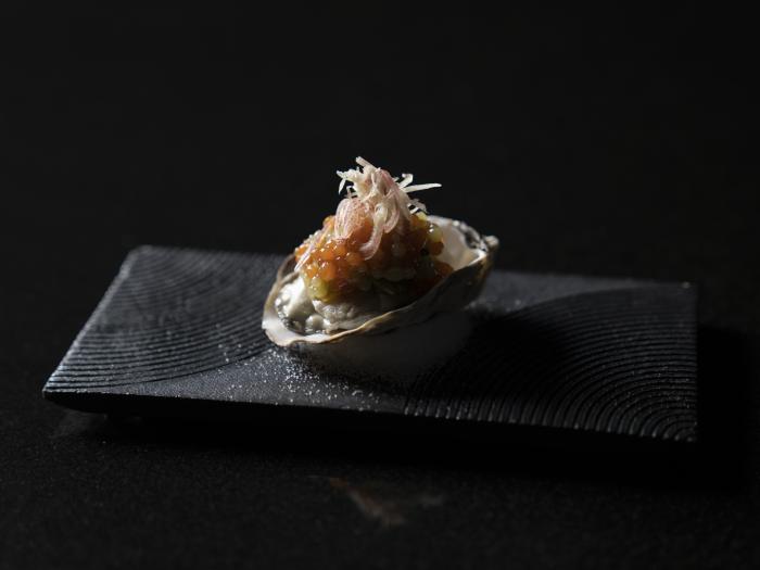 An oyster in tis shell draped in salmon roe.