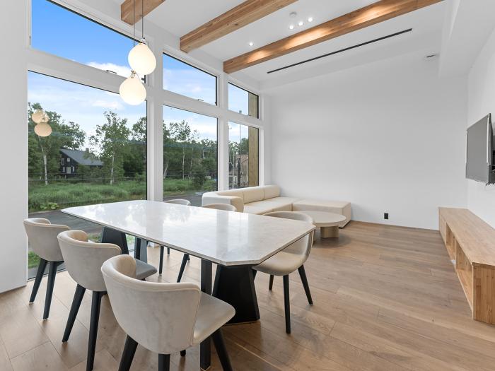 A dining table and sofa behind