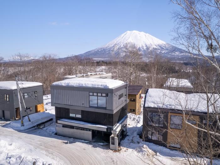 A two story home with Yotei behind
