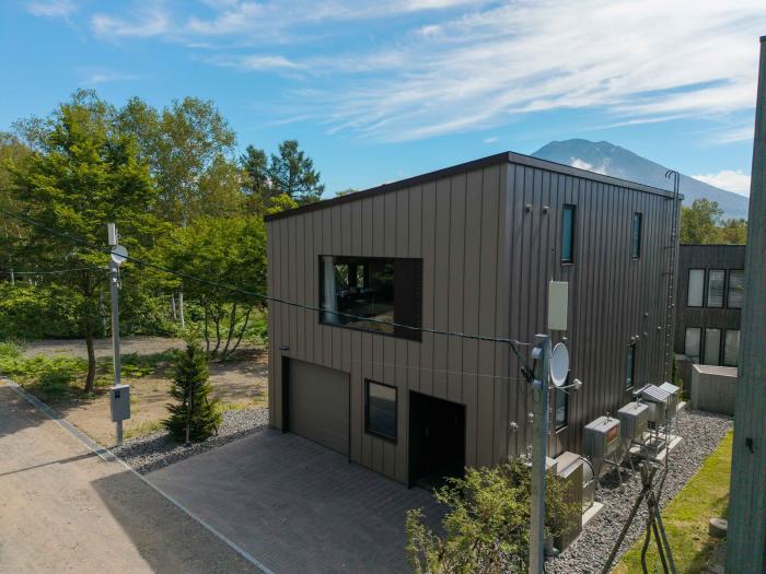 Setsuei Niseko exterior with garage, birch trees and Mt Yotei behind
