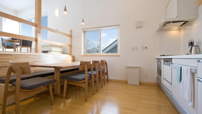 Dining table, edge of kitchen and rectangular window above