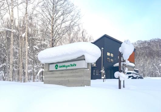 A snow covered Holiday Niseko sign