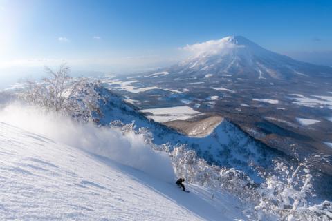 A snowboarder makes a turn in the powder