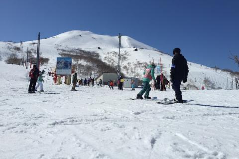 Skiers and snowboarders move toward a chair lift