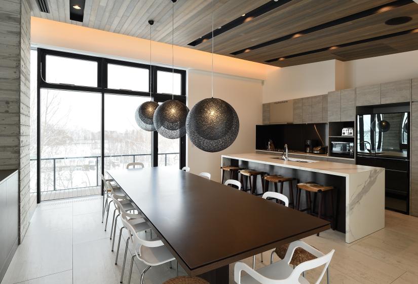 dining table with hanging orb lights and kitchen