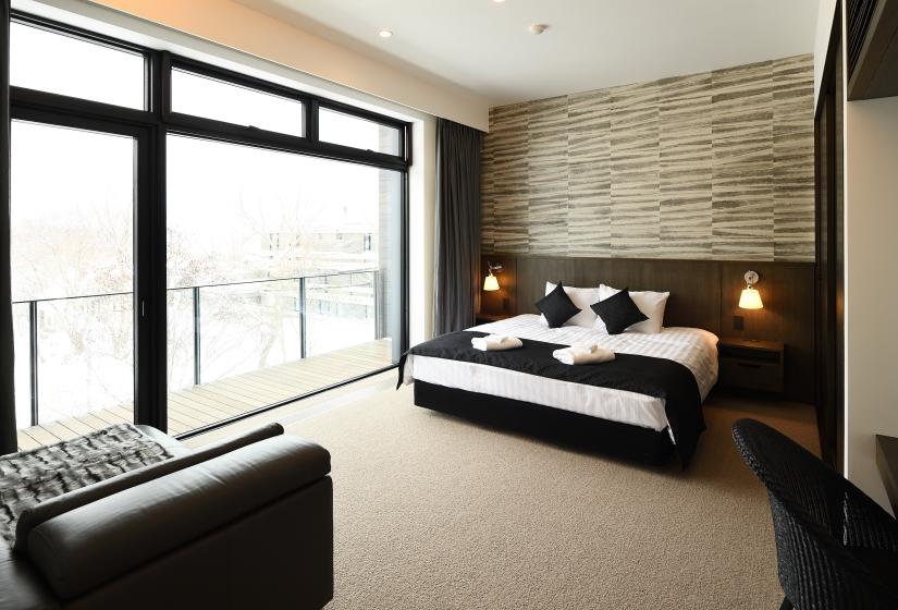 bedroom with bed, stone interior work, and large window