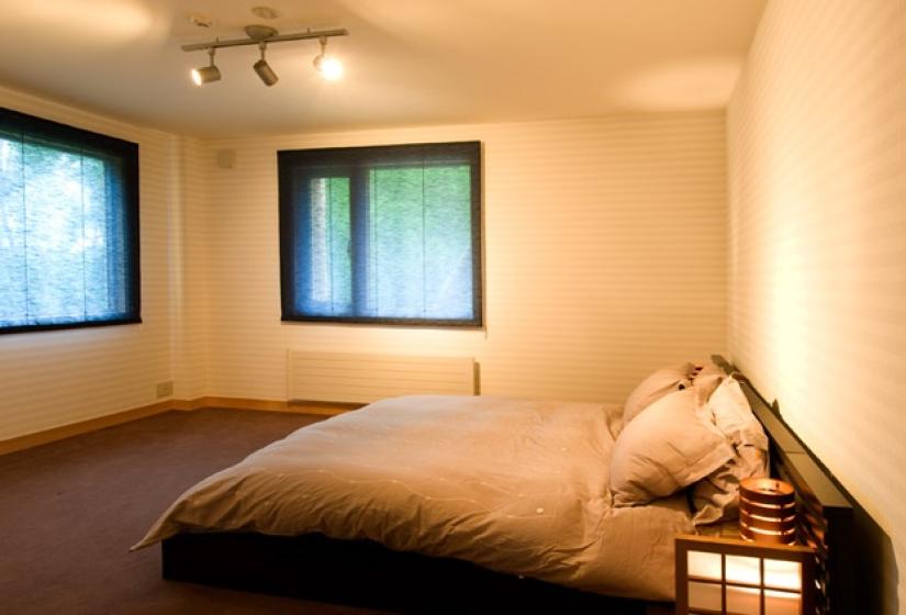 queen bed with exterior windows and lighting