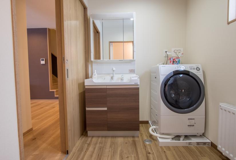 laundry machine located next to washroom sink