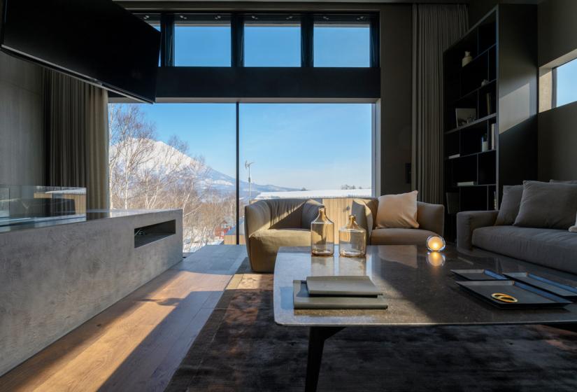 Interior living area with coffee table, couches, and large window views