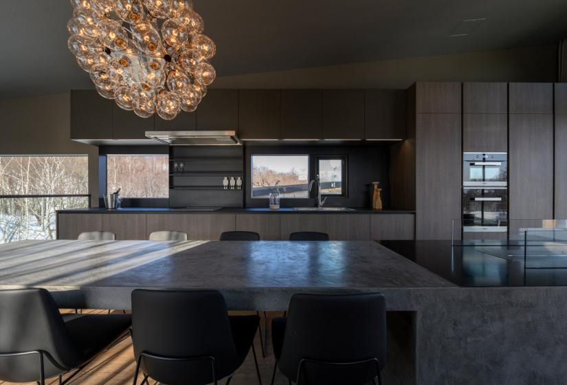 Chandelier with dining table and windows in background