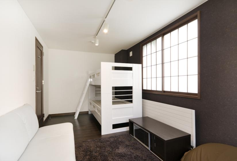 bunk bedroom with shoji screen window and couch