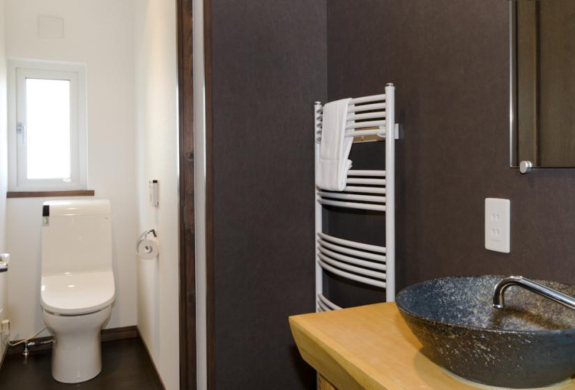japanese electronic toilet with stone sink and towel rack