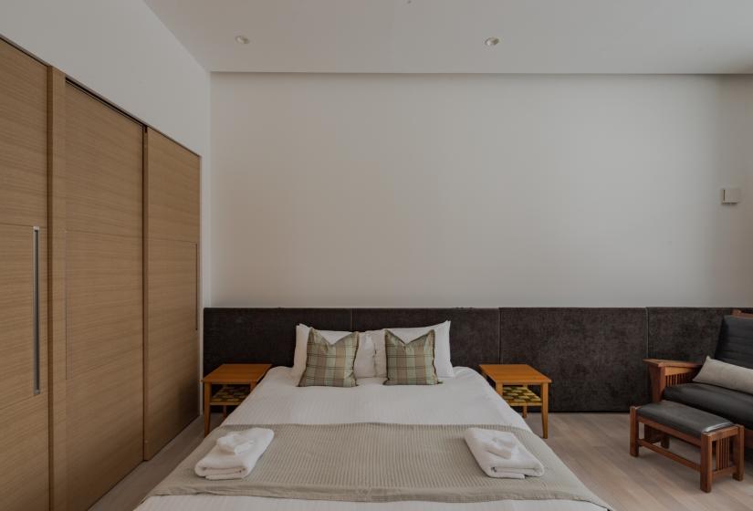 large bed with white walls and grey blankets