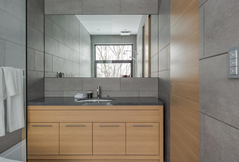 toilet with sink and wooden drawers