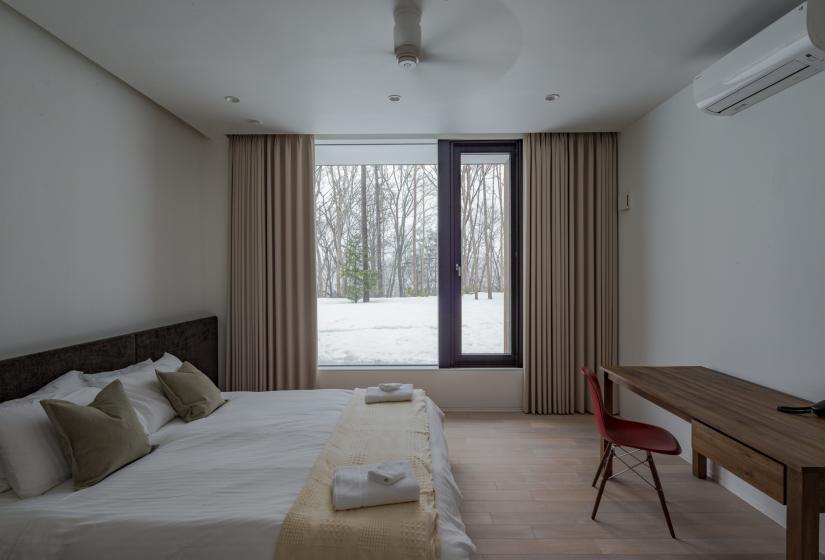 bedroom with desk, chair, and large window with curtains