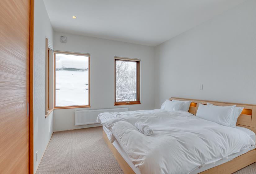 two twin beds with windows and white walls