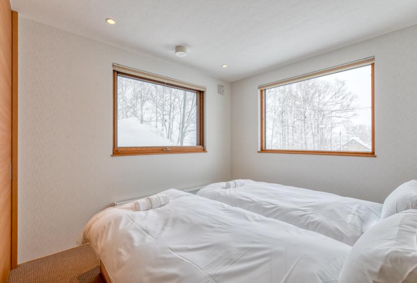 two twin beds with windows and white walls