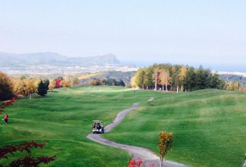 A golf course with autumnal trees and sea views