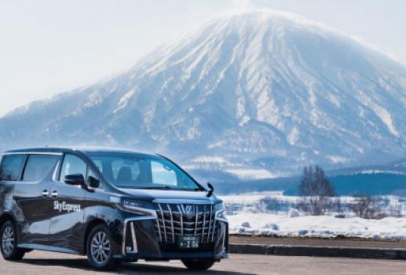 A black van with Mount Yotei in the back ground