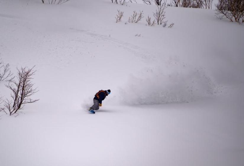 Snowboarding at Shimamaki Snowcats A snowboarder makes a deep turn