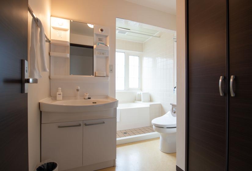 white vanity with bath in background