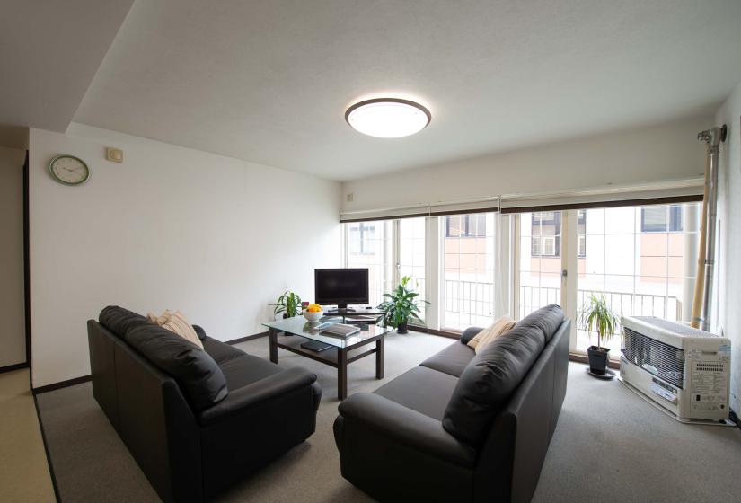 two black sofas facing a TV in the corner