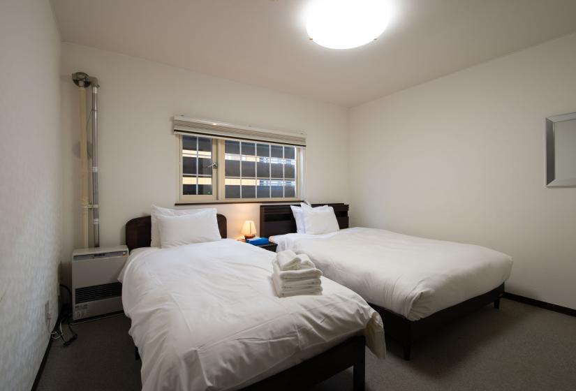 two single beds made up with white bedspreads