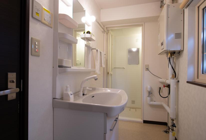 white vanity unit with shower in background