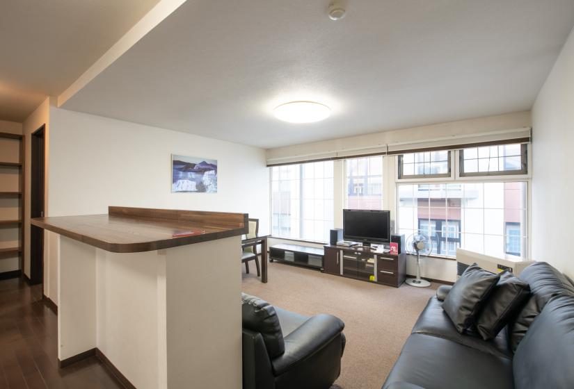 living room with 2 black sofas facing TV