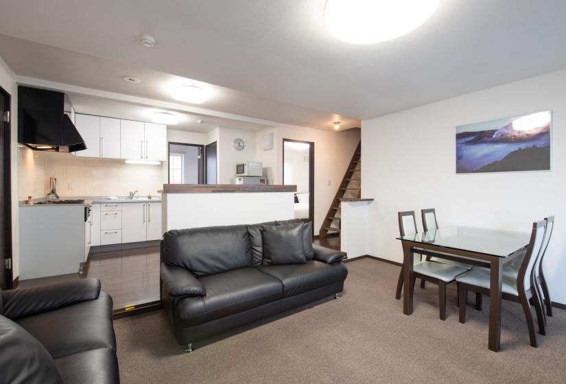 living area brown carpet with a black sofa