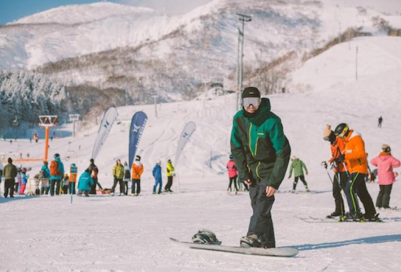 The base of Hirafu ski area A snowboarder prepares for action at the base of a ski slope