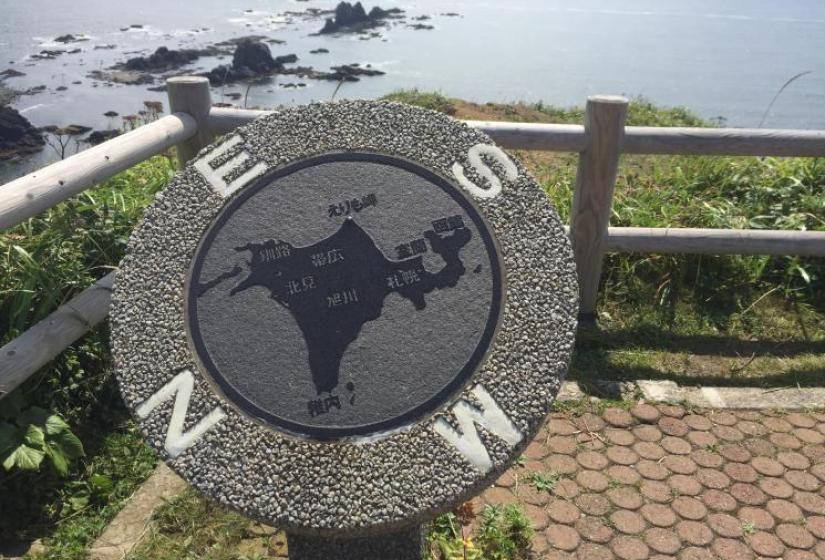 Concrete compass with rocky island in back ground