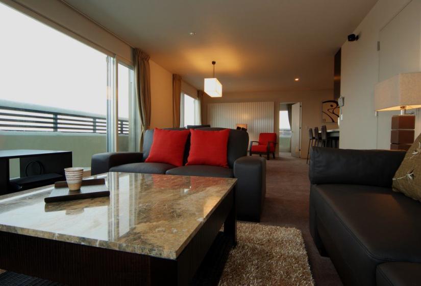 stone top coffee table with black leather couches and carpet