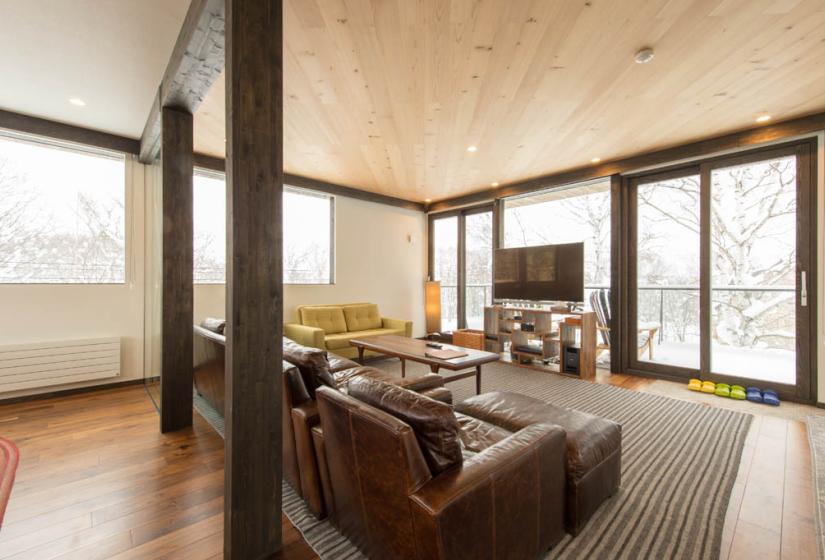 couches with tv and door to balcony in background