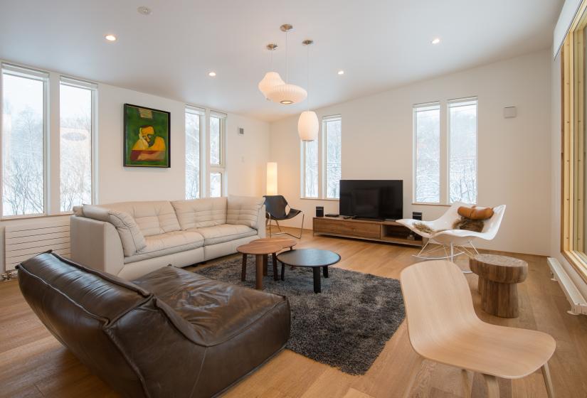 main living area with couches, Tv, chairs, and windows