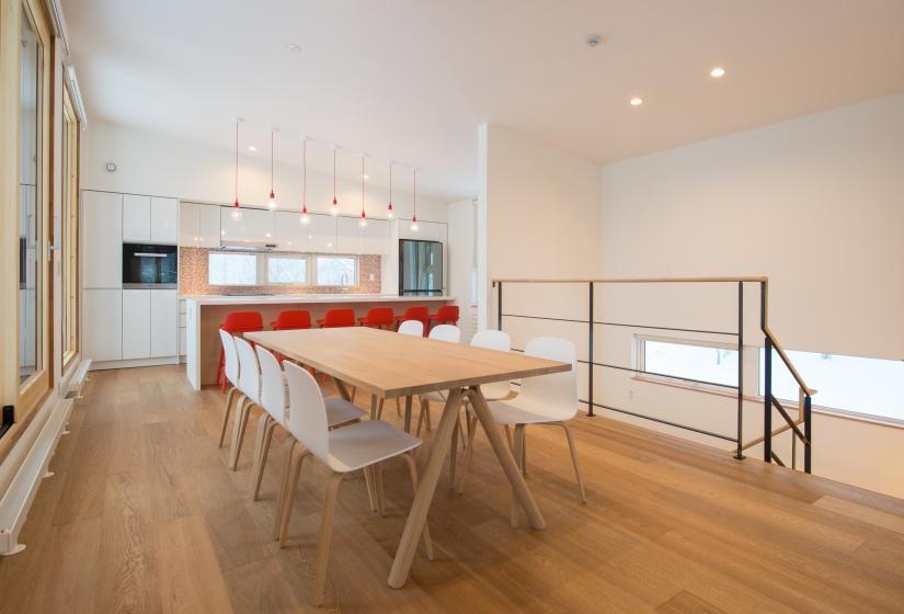 wooden dining table with white chairs and railing