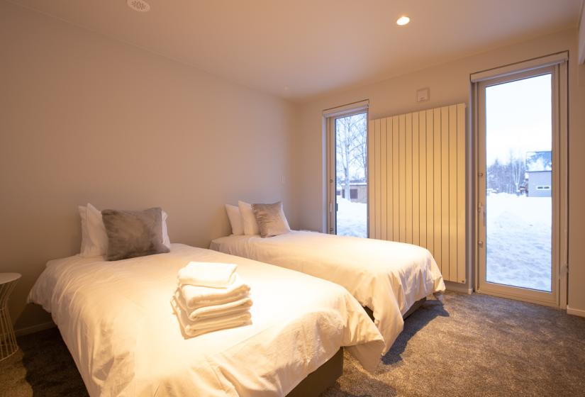 two single white beds with folded towels