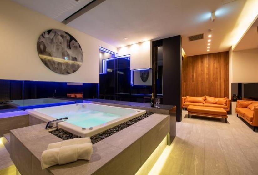 A jacuzzi with champagne bottles and lounge suite behind